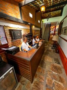 un grupo de personas sentadas en un mostrador en un restaurante en Pousada Estalagem do Porto, en Arraial do Cabo