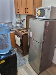 a kitchen with a refrigerator and a microwave on top of it at Alpha homes in Nakuru