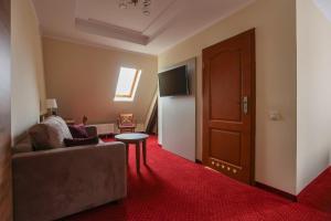 a living room with a couch and a table and a door at Pałacyk Karkonosze koło Karpacza in Karpacz