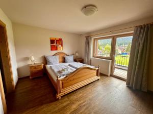 a bedroom with a bed and a large window at Appartementhaus Handl in Leutasch