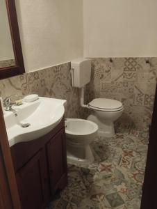uma casa de banho com um WC e um lavatório em Casa Luisa em Aggius