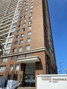 Un edificio alto con un cartel de "Tacos de salud" enfrente. en Edificio cerca de playa cavancha y Brava, en Iquique