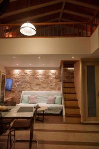 a living room with a couch and a staircase at Λειτουργικό σπίτι σε κεντρική τοποθεσία in Kalymnos