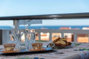 a table with a plate of bread and glasses at House Niki in Sarti