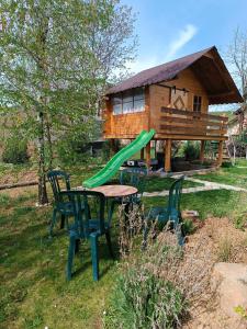 einen Tisch und Stühle sowie eine Rutsche vor einem Haus in der Unterkunft Naš san in Vrdnik