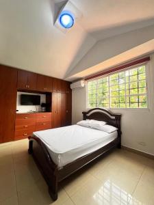 a bedroom with a bed and a large window at Habitación privada in Panama City