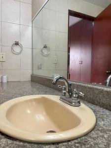 a bathroom sink with a faucet and a mirror at Habitación privada in Panama City