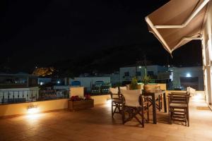 a table and chairs on a balcony at night at Λειτουργικό σπίτι σε κεντρική τοποθεσία in Kalymnos