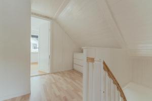 a white attic room with a staircase and a door at Charming 2BR Retreat in Vestmanna in Vestmanna +18 photos