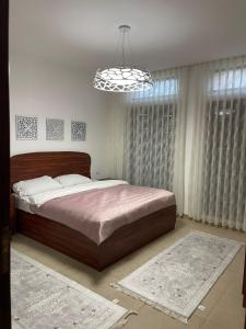 Un dormitorio con una cama grande y una lámpara de araña. en Romantic chalet between swimming pools and close to the seashore, en Áqaba