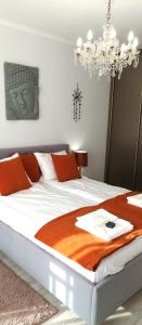 a bedroom with a large white bed with a chandelier at Planet Gdansk Apartments Merkury Old Nova in Gdańsk