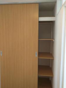 a closet with wooden doors and wooden shelves at Apartment Bugenvila in Vrboska