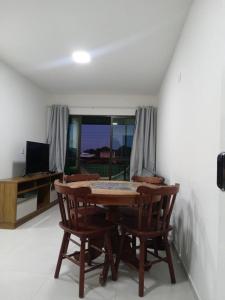ein Esszimmer mit einem Tisch und zwei Stühlen in der Unterkunft Apartamento Praia do Francês in Marechal Deodoro