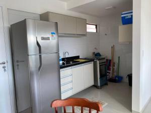 eine Küche mit einem Kühlschrank aus Edelstahl und einer Spüle in der Unterkunft Apartamento Praia do Francês in Marechal Deodoro