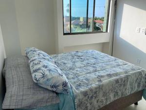 ein Bett in einem Zimmer mit Fenster in der Unterkunft Apartamento Praia do Francês in Marechal Deodoro + 50 Fotos