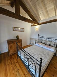 een slaapkamer met een zwart bed en een houten vloer bij Villa Panorama in Pomoshtitsa