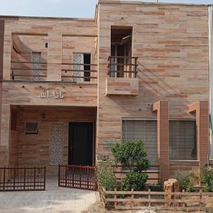 fachada de madera de una casa con balcón en Balqees Cottage en Lahore