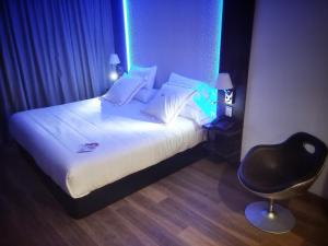 a bedroom with a bed and a chair in a room at MB Boutique Hotel - Adults Recommended in Nerja
