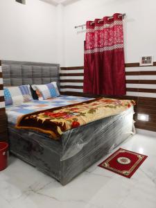 a large bed in a room with a red curtain at Shanti Kunj Yatri Niwas in Ayodhya