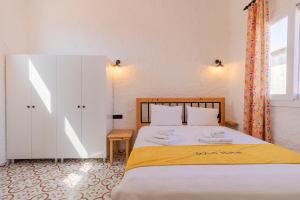a bedroom with a large bed with a yellow blanket at Das Hotel Alacati in Alaçatı