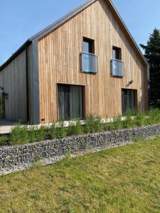 a wooden house with windows and a stone wall at Zielnisko in Firlej