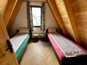 two beds in a room with a window at Vlasic Odmor - Villa Una & sauna in Vlasic