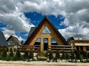 una casa de madera con techo de gambrel en Villa Una & sauna en Vlasic