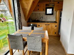 ein Esszimmer mit einem Tisch, Stühlen und einem Fenster in der Unterkunft Villa Una & sauna in Vlasic