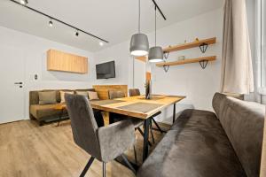una sala da pranzo con tavolo e divano di Apartmant Roleen TopC32 by Four Seasons Apartment a Kaprun
