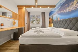 un grande letto in una camera da letto con un dipinto sul muro di Apartmant Roleen TopC32 by Four Seasons Apartment a Kaprun