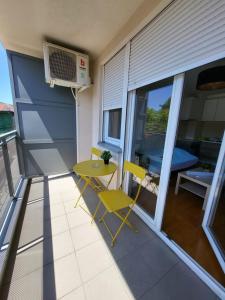 eine kleine Terrasse mit einem Tisch und Stühlen auf dem Balkon in der Unterkunft Apartmani Simić Quatro in Valjevo