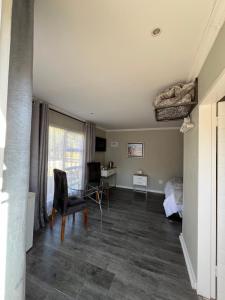 1 dormitorio con cama, escritorio y silla en Manna House en Vereeniging