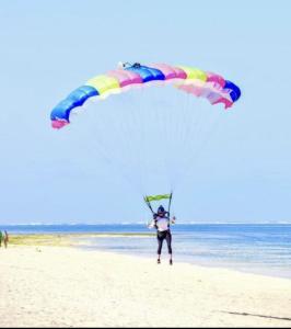 una persona sosteniendo un paracaídas en la playa en Awali Villa B33, en Vipingo