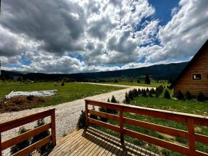 a wooden bench sitting on a path next to a house at Microcastl in Vlasic