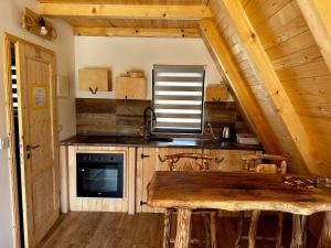 eine Küche mit einem Holztisch in einer Hütte in der Unterkunft Microcastl in Vlasic