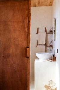 uma casa de banho com um lavatório, um espelho e uma porta em The O Experience - Tayourt Lodge em Imsouane