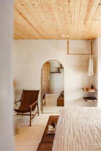 1 dormitorio con cama y techo de madera en The O Experience - Tayourt Lodge, en Imsouane