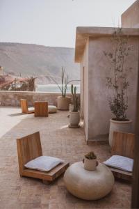 a patio with chairs and potted plants with a view at The O Experience - Tayourt Lodge in Imsouane
