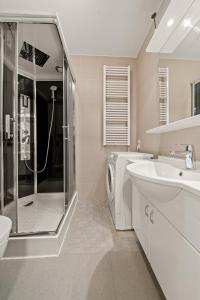 bagno con lavandino e lavatrice di Apartmant Roleen TopC32 by Four Seasons Apartment a Kaprun