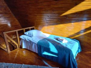 małe łóżko w pokoju z drewnianymi ścianami w obiekcie Cottage Hillside in Juta w mieście Juta