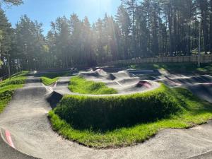 a skate park with a skateboard ramp with grass at Poppy Lodge in Boat of Garten