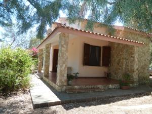 a small house with a porch in front of it at Villa dei Pini , Solanas Villasimius in Solanas