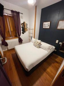 1 dormitorio pequeño con 1 cama con sábanas blancas en El Torreon de Navacerrada en Navacerrada