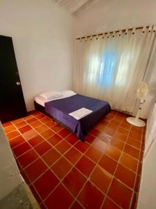 a bedroom with a bed and a red tile floor at El Palmar in Guaduas