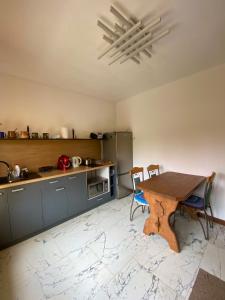 a kitchen with a wooden table and chairs in it at City Travel apartments in Rēzekne