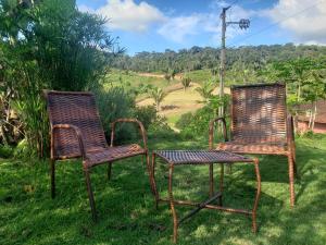 Deux vieilles chaises assises dans l'herbe d'une cour dans l'établissement Casa no Caravaggio ao lado da cervejaria 3 Santas, à Santa Teresa
