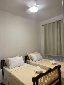 una camera con due letti con asciugamani di Casa com piscina em Piratininga a Niterói