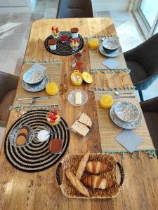 a wooden table with plates and food on it at Le Repos du Keyrié in Saint-Marc-Jaumegarde