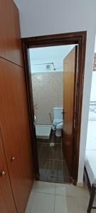 a bathroom with a toilet and a door to a room at Star Sianna Village Rooms to let in Siána
