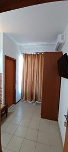 ein leeres Wohnzimmer mit einer Tür und einem Vorhang in der Unterkunft Star Sianna Village Rooms to let in Siána